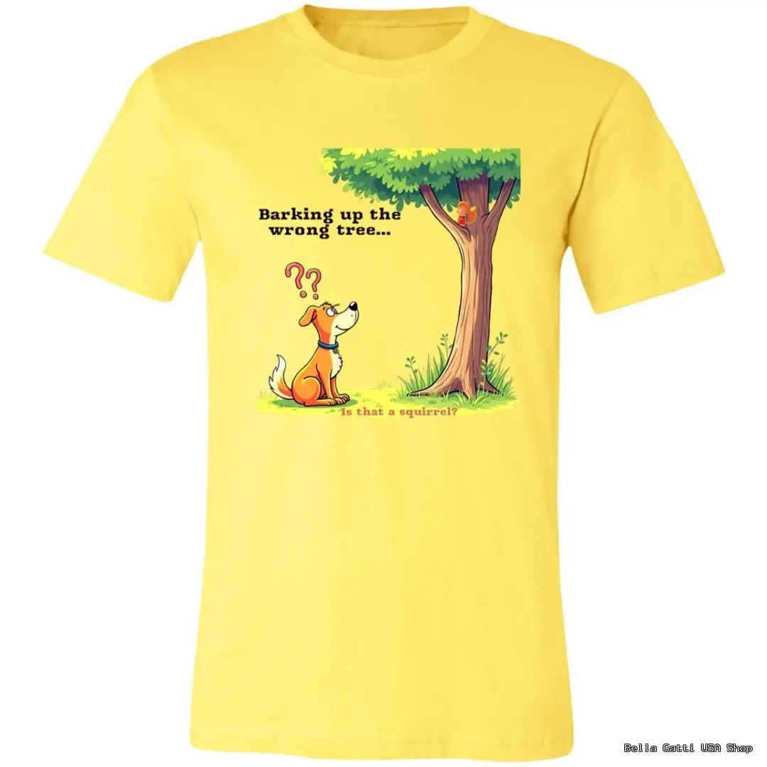 A yellow t-shirt with a cartoon of a confused orange dog looking up at a squirrel in a tree. Above the dog, text reads Barking up the wrong tree... and below, Is that a squirrel? The scene is bright and playful with a grassy ground.