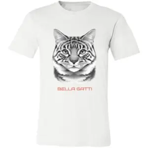 A white T-shirt features a detailed, realistic black-and-gray cat face illustration centered on the chest. Below the cat’s face, the words “BELLA GATTI” are written in bold, orange capital letters.