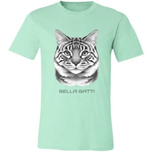 Light green T-shirt with a realistic black and white illustration of a tabby cat’s face centered on the chest. Below the cat image, the text “BELLA GATTI” is printed in uppercase letters. The T-shirt is displayed on a plain background.