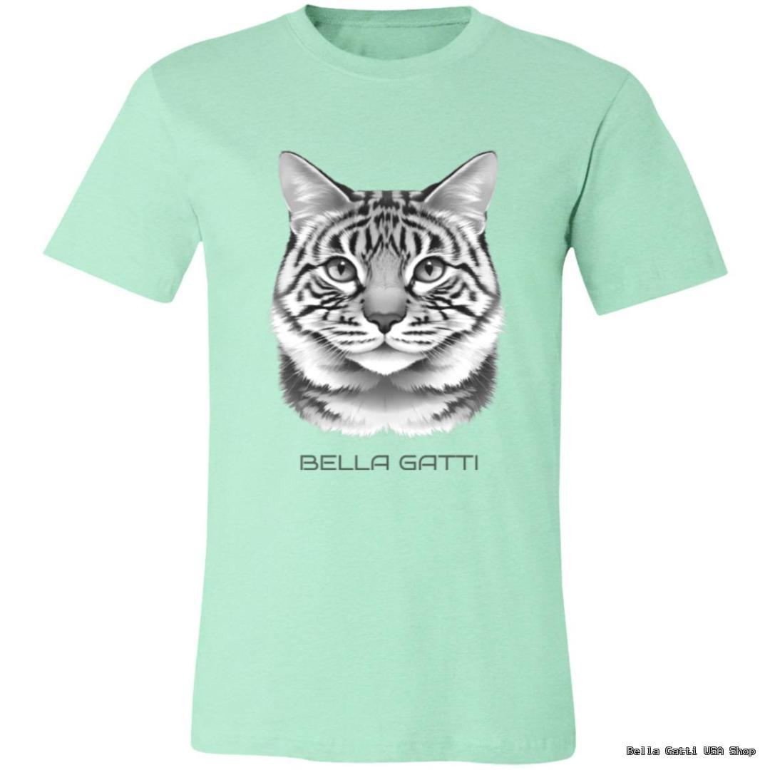 Light green T-shirt with a realistic black and white illustration of a tabby cat’s face centered on the chest. Below the cat image, the text “BELLA GATTI” is printed in uppercase letters. The T-shirt is displayed on a plain background.