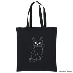 A black tote bag features a simple white line drawing of a seated cat, facing forward with its tail curled around its body. The cat has large eyes and long whiskers. The background is plain white.