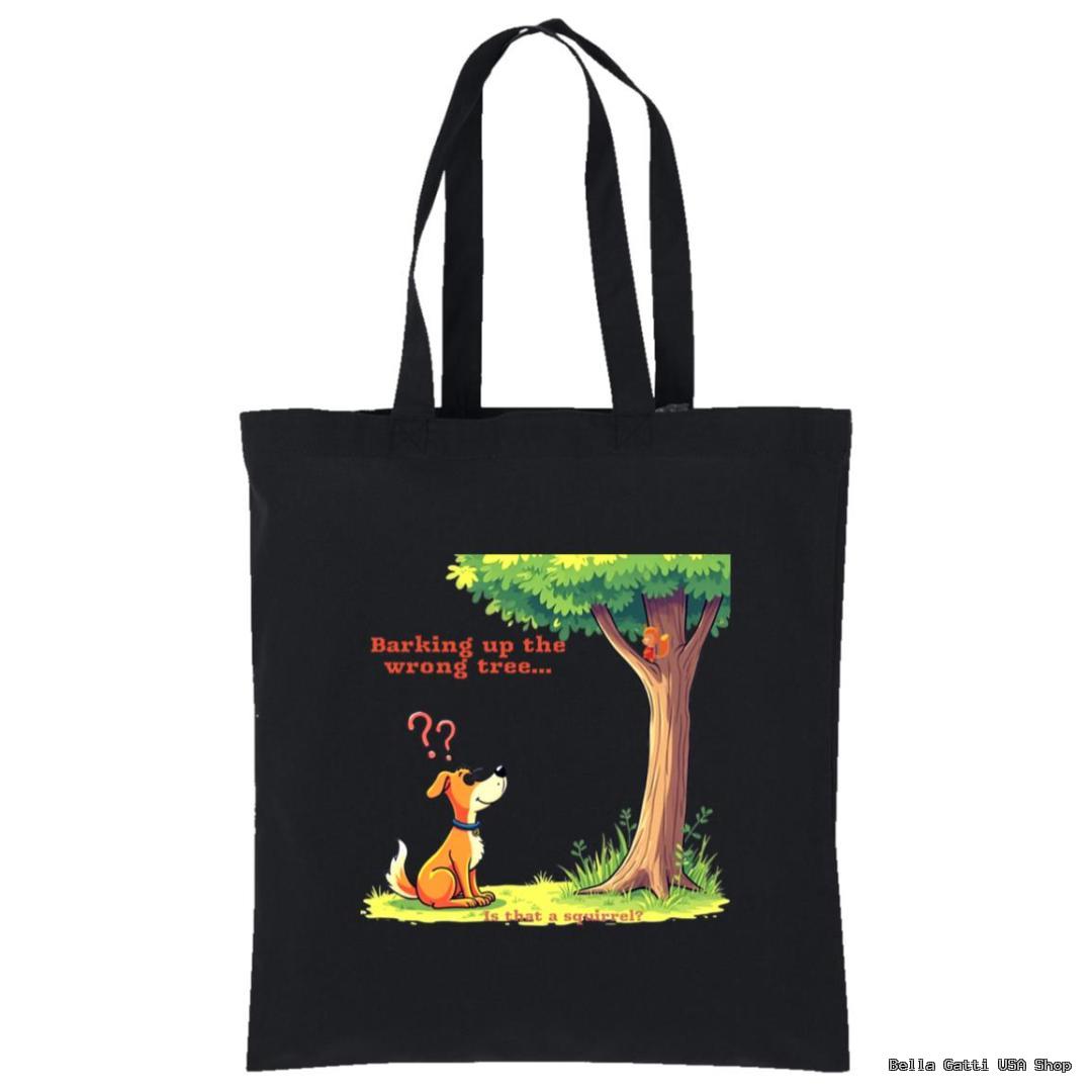 A black tote bag features a cartoon dog sitting and looking up at a tree with a squirrel on a branch. Red question marks are above the dog’s head. The text reads, “Barking up the wrong tree…” in red and orange letters.