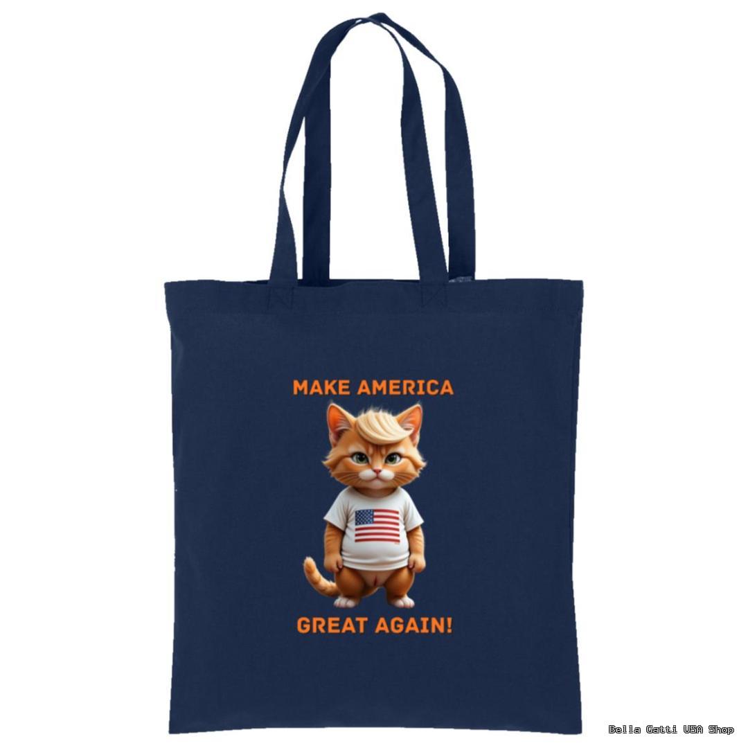 A navy blue tote bag features a cartoon orange cat wearing a white shirt with an American flag. Above and below the cat, orange text reads “MAKE AMERICA GREAT AGAIN!” The bag has long handles for carrying.