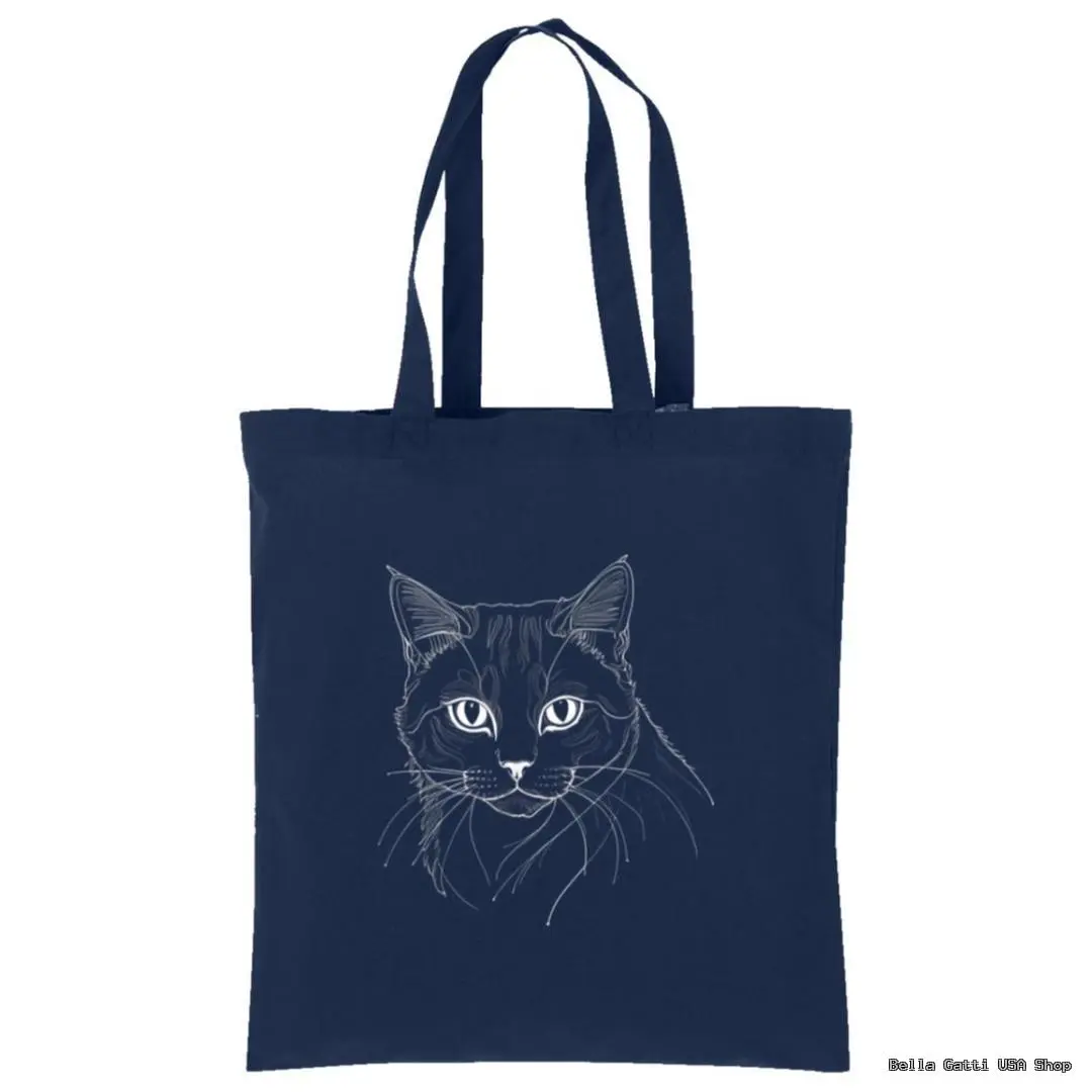 A navy blue tote bag featuring a minimalist white line drawing of a cats face with expressive eyes and detailed fur. The bag has two long handles for carrying and a plain background, highlighting the simple yet elegant cat illustration.