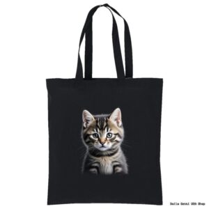 A black tote bag with two handles features a realistic print of a gray tabby kitten with white markings, bright eyes, and perky ears centered on the front. The background is plain, making the kitten the focus of the design.
