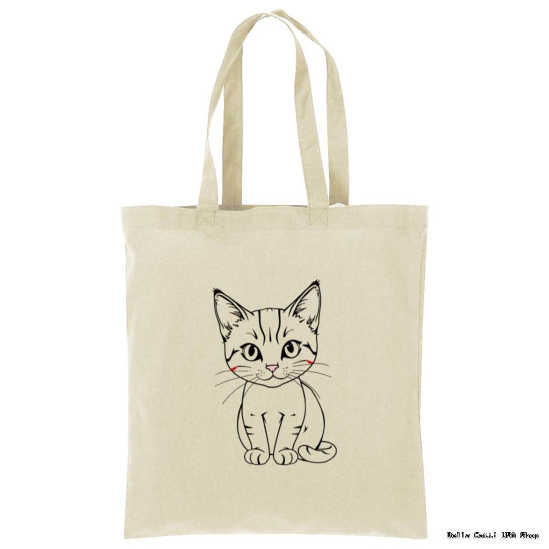 A beige tote bag features a simple black line drawing of a cute, sitting kitten with wide eyes and a small smile. The kitten has slightly rosy cheeks. The background is plain white.