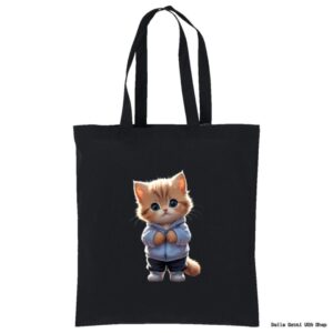 A black tote bag featuring an illustration of a cute orange and white kitten with big blue eyes, standing upright and wearing a light blue hoodie and sneakers. The kitten appears centered on the bag’s front.
