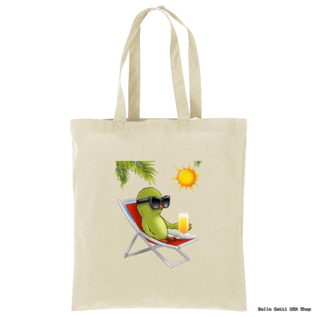 A beige tote bag features a cartoon avocado lounging on a beach chair, wearing black sunglasses, holding a drink, with a sun and palm leaves above. The background is plain.