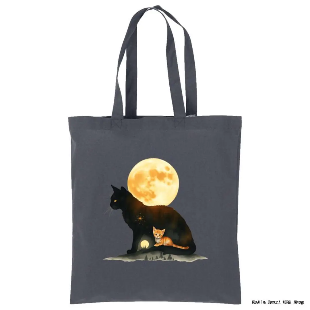 A dark gray tote bag features an illustration of a large black cat with a bright full moon behind it. Inside the black cat’s silhouette, a small orange cat sits on a patch of grass, a glowing yellow moon and stars surrounding them, creating a magical scene.
