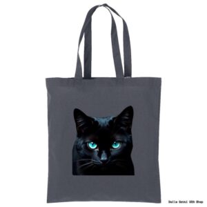 A dark gray tote bag features a realistic print of a black cat’s face with striking, bright blue eyes centered on the front. The bag has two long handles and is displayed against a plain white background.