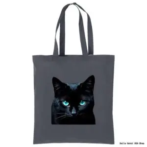 A dark gray tote bag features a realistic print of a black cat’s face with striking, bright blue eyes centered on the front. The bag has two long handles and is displayed against a plain white background.