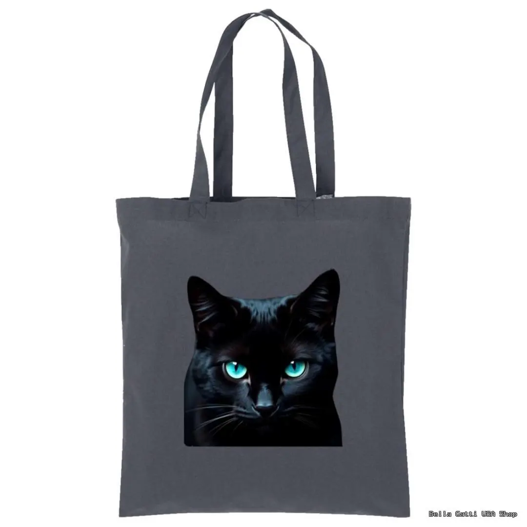 A dark gray tote bag features a realistic print of a black cat’s face with striking, bright blue eyes centered on the front. The bag has two long handles and is displayed against a plain white background.