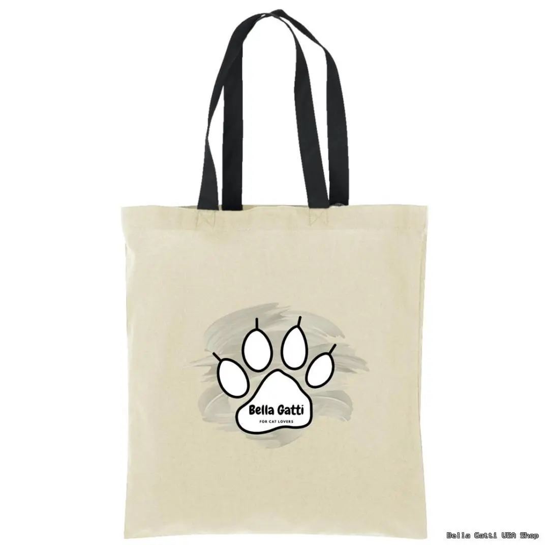 A beige tote bag with black handles features a large black paw print on the front. Inside the paw print, it reads Bella Gatti FOR CAT LOVERS in black text. Behind the paw print is a subtle gray brushstroke design.