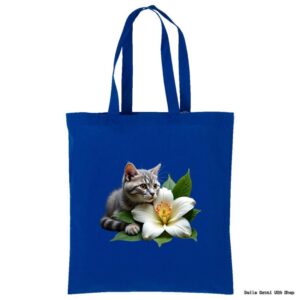 A royal blue tote bag features a realistic image of a gray tabby kitten lying beside a large white flower with green leaves. The kitten is gazing intently to the side. The background is plain, highlighting the bag and its design.
